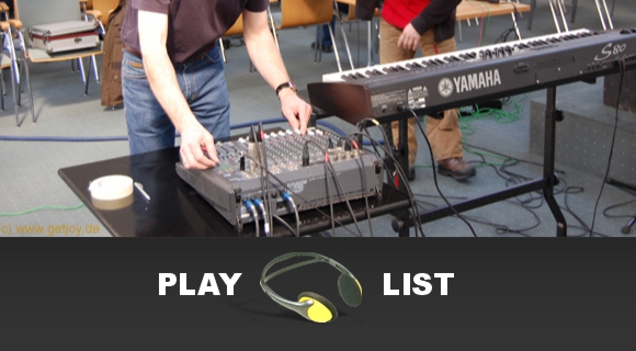 Titel: Playlist. Bild: Aufbau von Keyboard, Mischpult, Mikrofone und Technik.